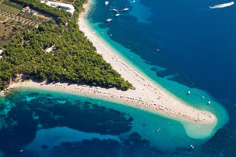 From Split: Catamaran Cruise to Golden Horn & Brač island. - Swim stops at hidden bays: Lučice and two extra water breaks